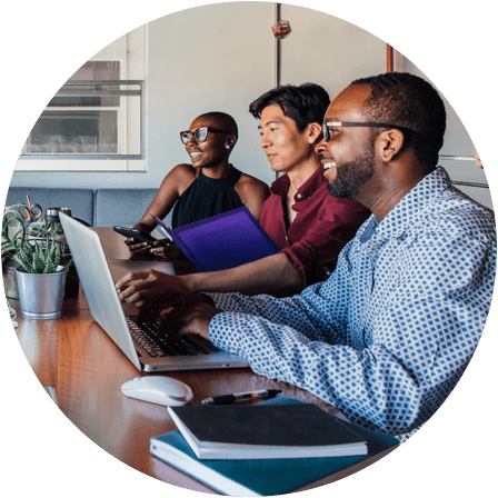 Circle photo of employees working at a communal desk