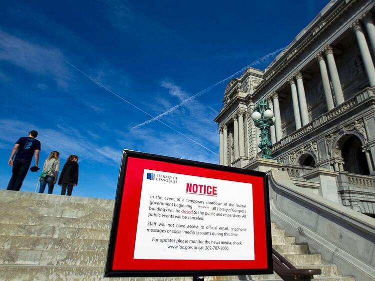 Close up of a sign disclaiming the closing of the library of congress in front of the library of congress