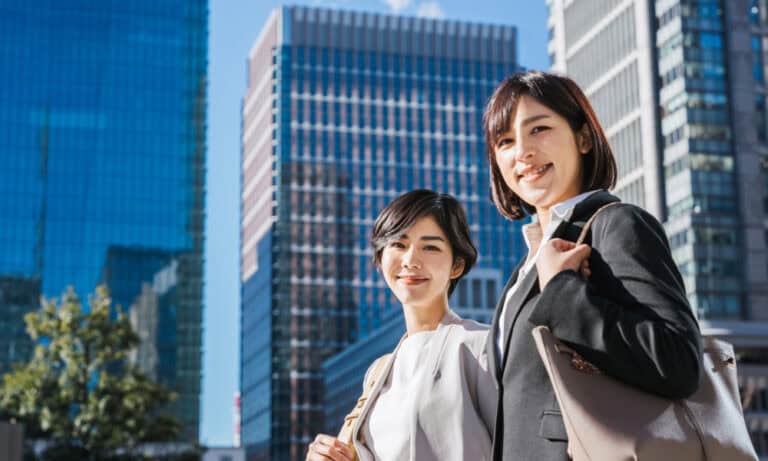 women in business attire smiling